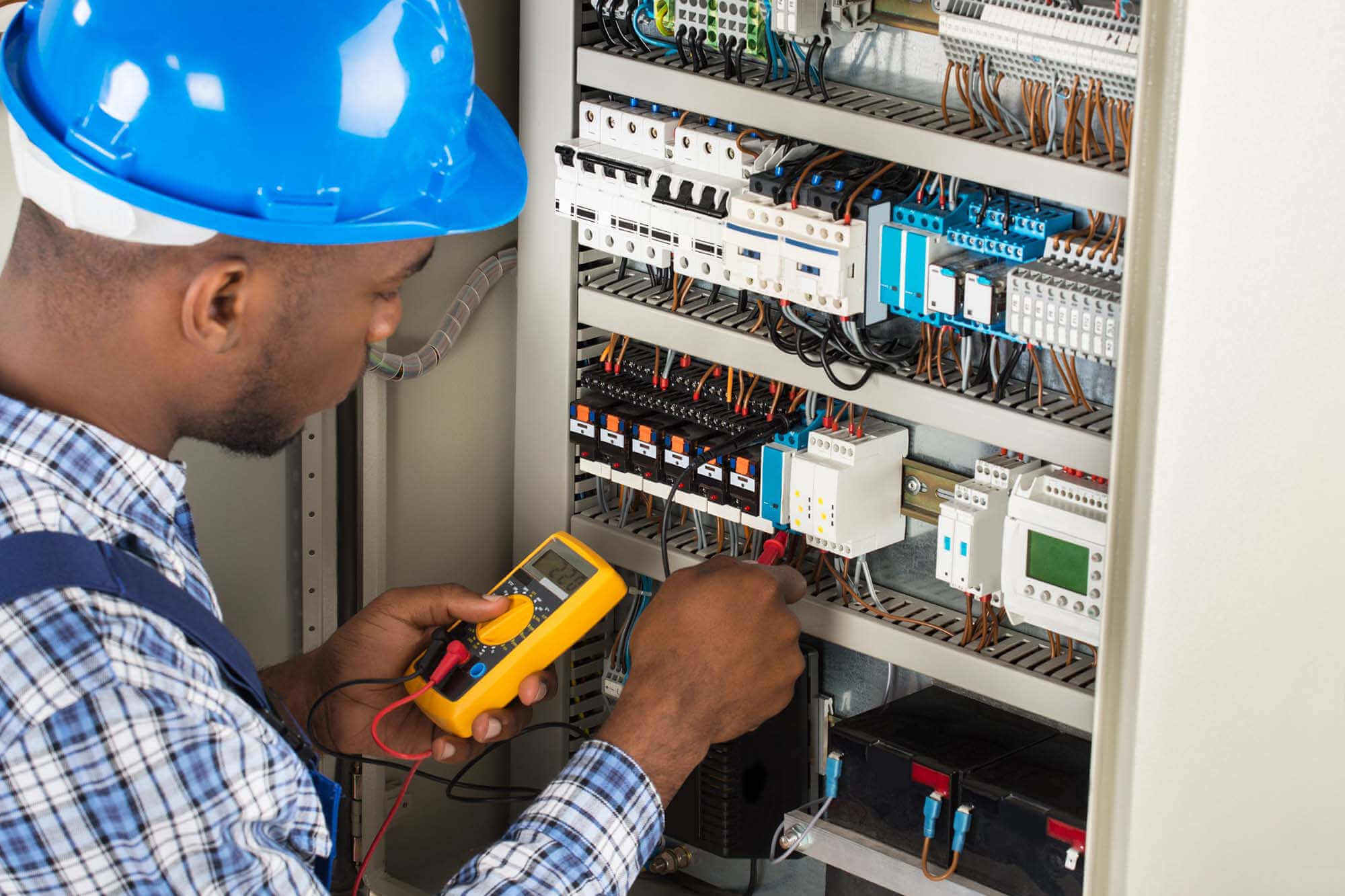 Electrician working on electrical wiring with a multimeter